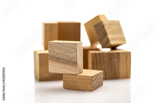 Piece of wooden puzzle close-up isolated on white background  on defocused pyramid. Business success concept. Layout for presentation.