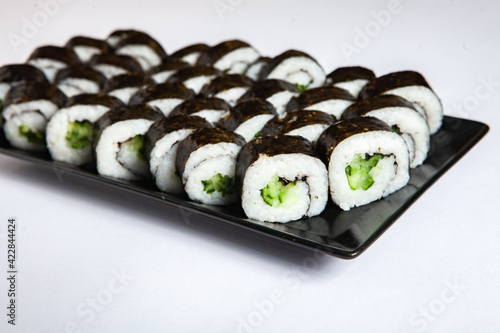 Fresh delicious japanese sushi with avocado on white background.