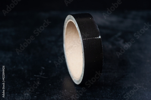 Black narrow adhesive tape for use in filmmaking on a dark background