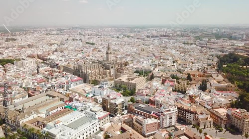 Drone point of view of Seville Cathedral, and city center. Famous travel destination in Spain. Empty street due to Corona Virus measures. Drone forward above the Triumfo Square. No tourists photo