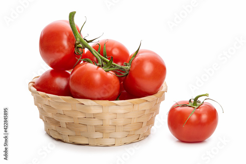 bunch of tomatoes in a wicker bowl. Isolate on white background 