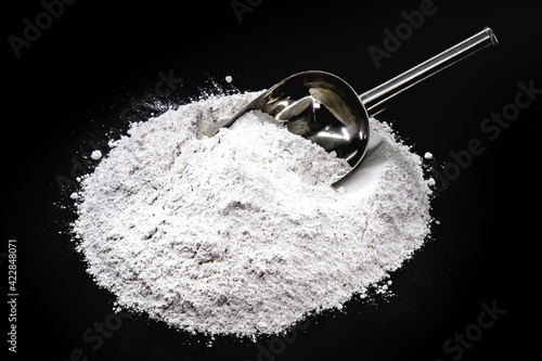 magnesium sulfate on black isolated background with metal spoon