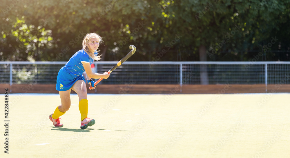 Young field hockey female player on the pitch