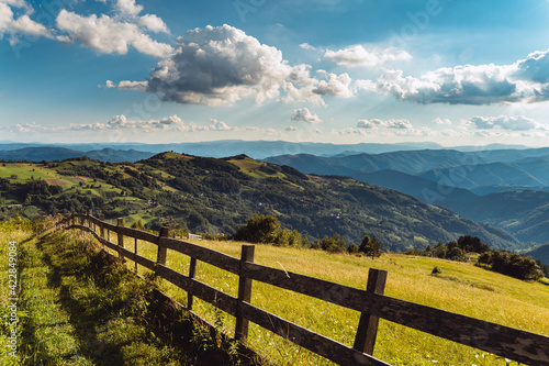 wooden fence along the grassy hillside. beautiful springtime landscape