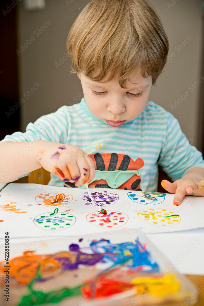 Easter activities at home. Make fun during quarantine. Kid decorating printed egg shapes with ear buds and gouache. DIY games at home. Easter activities at home. Make fun during quarantine. Kid decorating printed egg shapes with ear buds and gouache. DIY games at home.