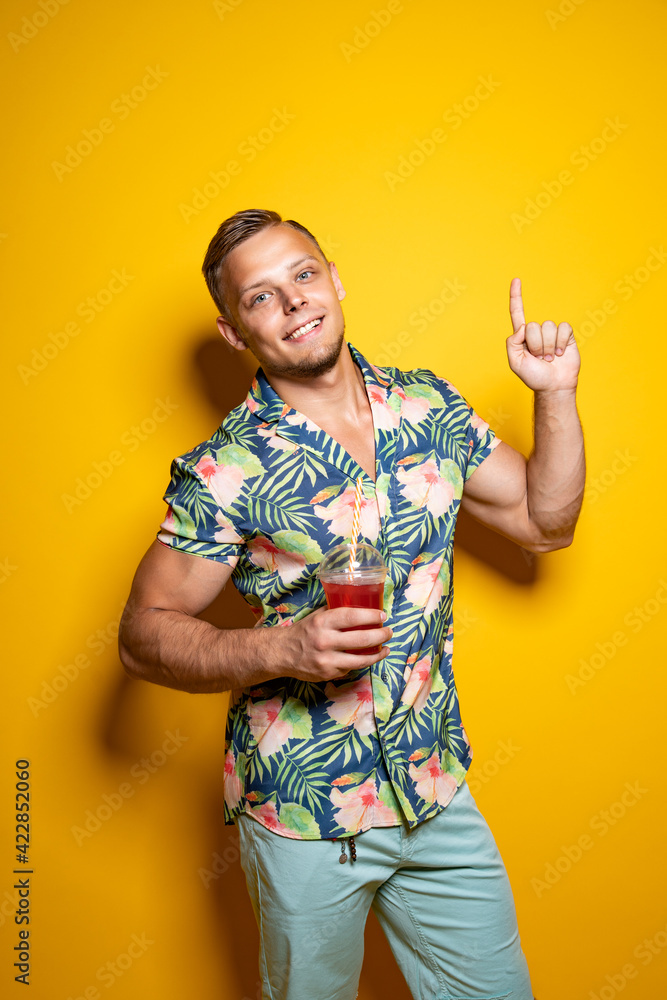 Man in bright clothes with beverage on yellow Man in bright clothes with beverage on yellow
