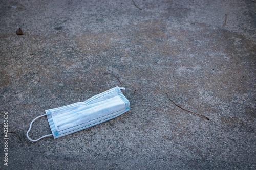 Blue Protective Mask Discarded on the Sidewalk