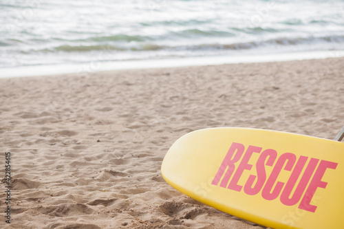 Photography Yellow surf rescue board by the sea beach.