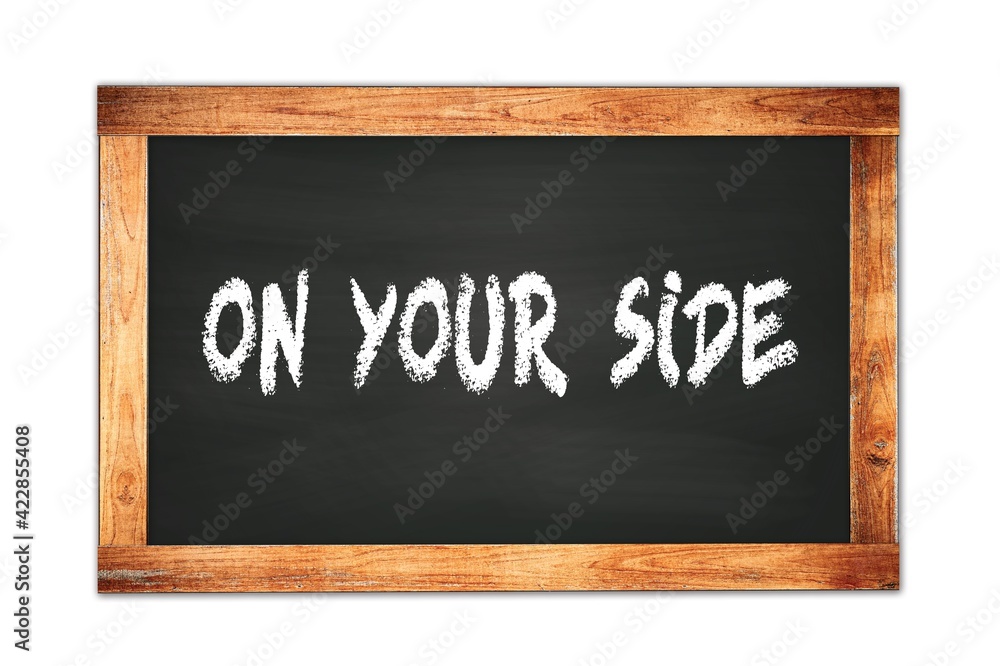 Fototapeta premium ON YOUR SIDE text written on wooden frame school blackboard.