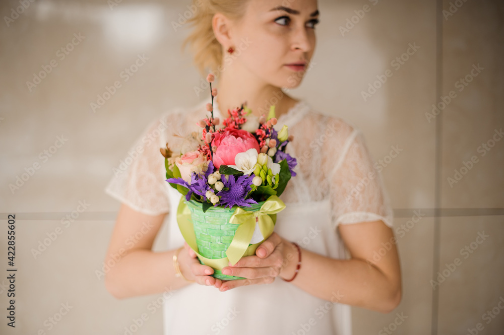 cute easter arrangement of flowers in wicker pot in the hands of woman