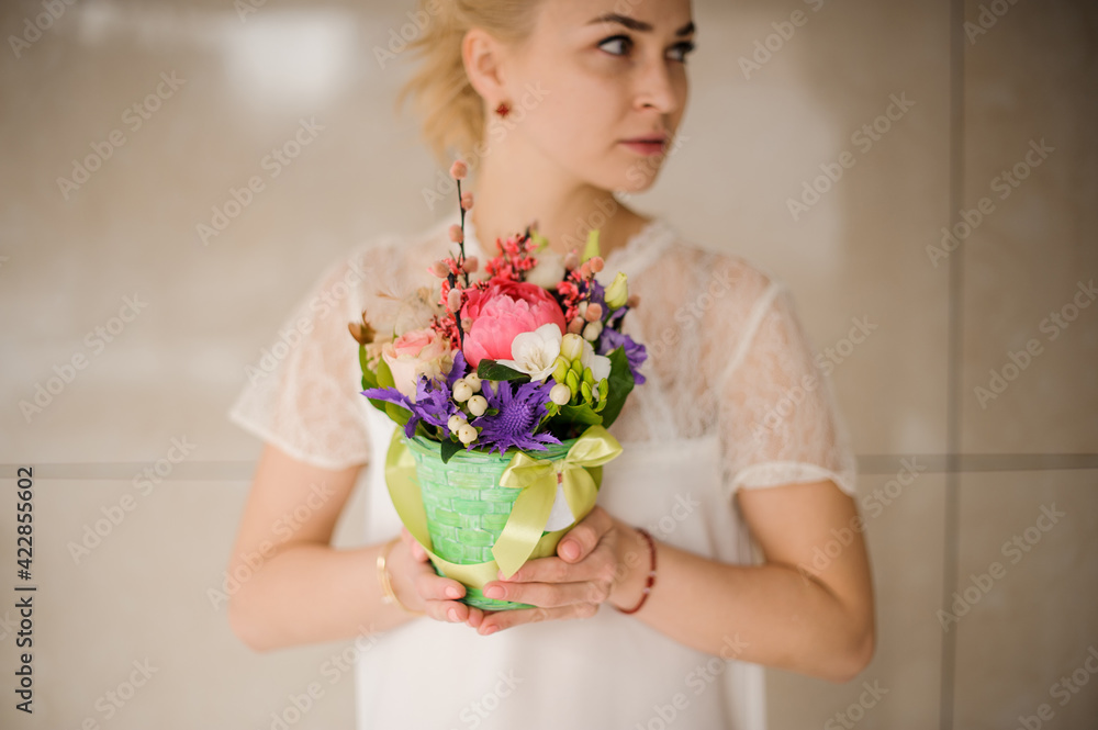 cute easter arrangement of flowers in wicker pot in the hands of woman cute easter arrangement of flowers in wicker pot in the hands of woman