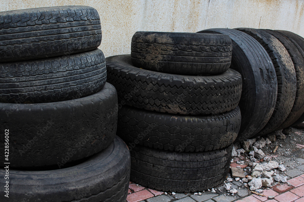 Obraz premium Group of old used car tires on the display in the street. Horizontal image