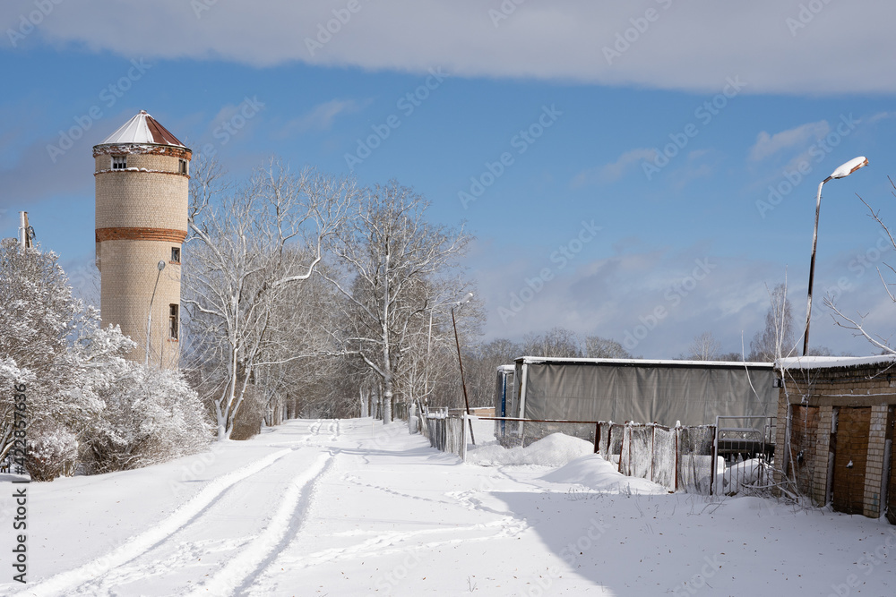 White snowy winter day in the Latvian countryside with a large brick water