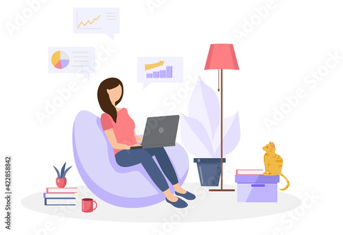 The girl sits on a bag chair in the home interior and works on a laptop. Work from home concept