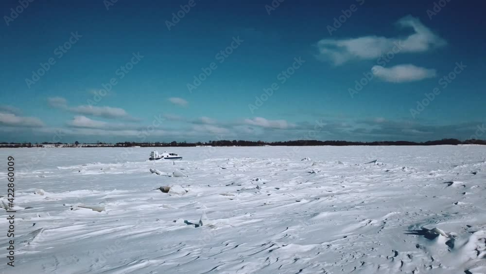 Aerial photography: Hovercraft rides on an ice-covered river in winter Aerial photography: Hovercraft rides on an ice-covered river in winter