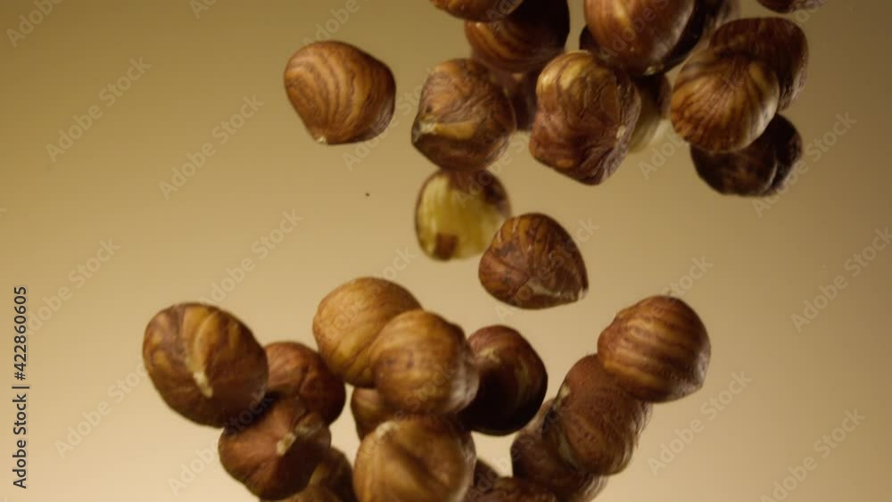 Beautiful hazelnuts falling in slow motion over a brown background Beautiful hazelnuts falling in slow motion over a brown background