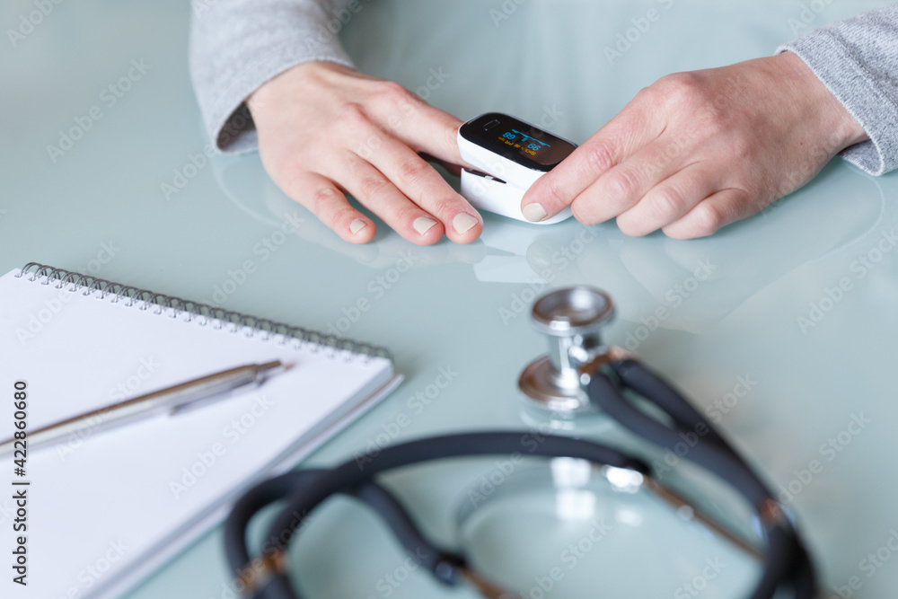 Female patient hand measuring oxygen saturation and pulse using portable oximeter. Female patient hand measuring oxygen saturation and pulse using portable oximeter.
