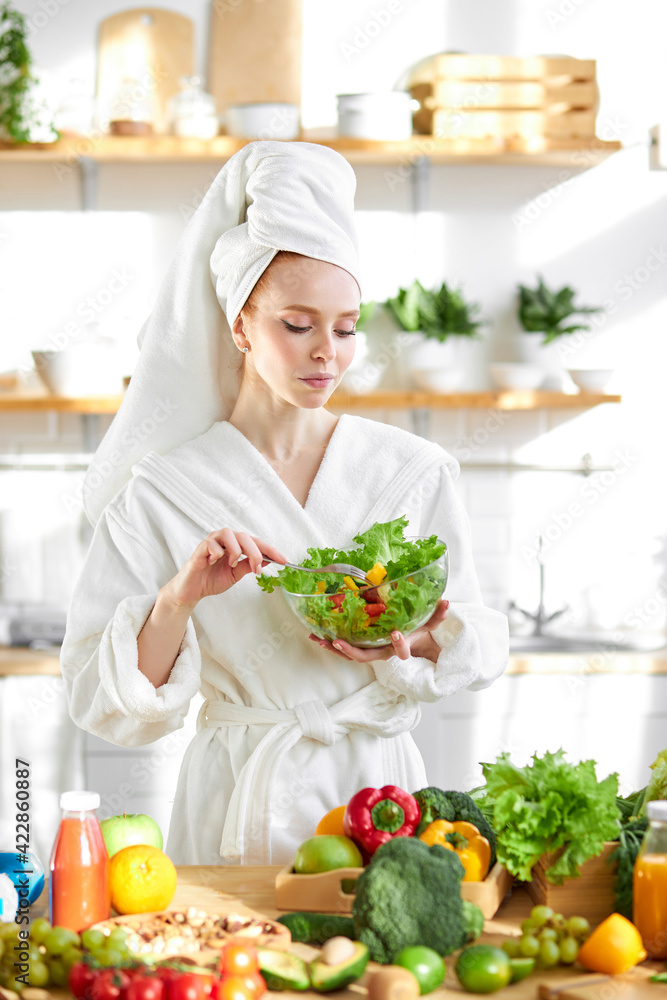 healthy young female in bathrobe enjoy making and eating fresh salad from vegetables healthy young female in bathrobe enjoy making and eating fresh salad from vegetables