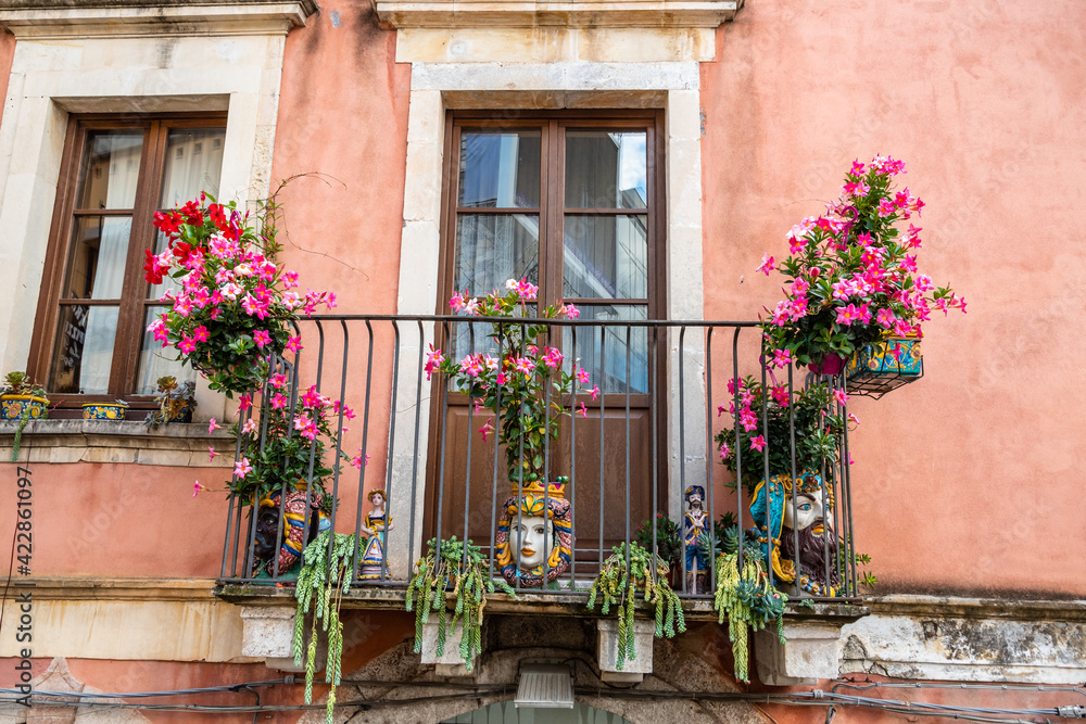 Typical Sicilian balcony in Taormina full of flowers and decorations Typical Sicilian balcony in Taormina full of flowers and decorations