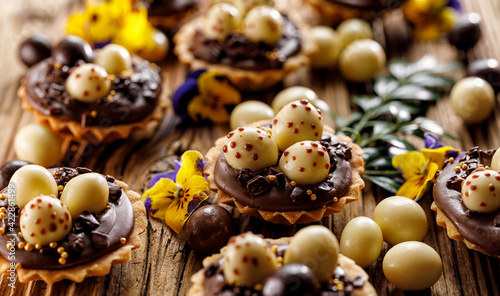 Canvas Print Close up view of an Easter mini tart with chocolate Easter eggs on a wooden table