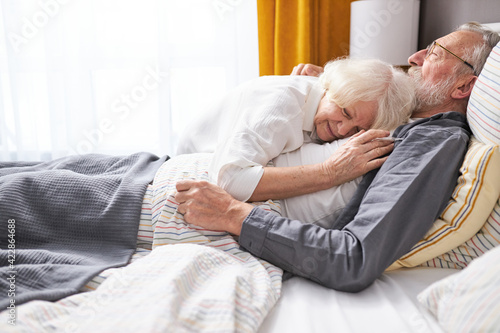 Photos elderly woman hugging sick husband lying on bed