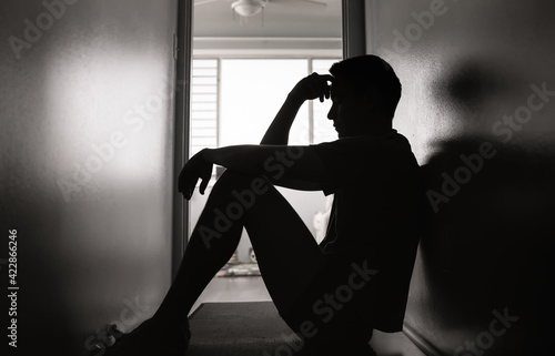 Sad man sitting in a dark room 