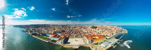 Aerial panoramic view of Lisbon city coast and old town at sunny summer day. View from Tagus river. Commerce Square or Praca do Comercio in Lisbon city centre, Portugal. Lisbon aerial skyline