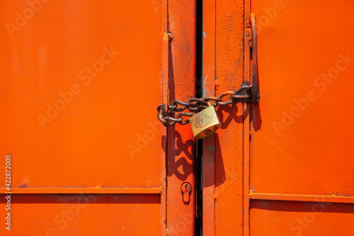 Orange metal garage door with locker and iron chain