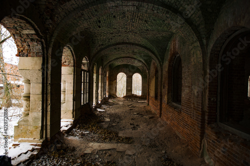 Dark corridor of old ancient abandoned red brick ruined historical building