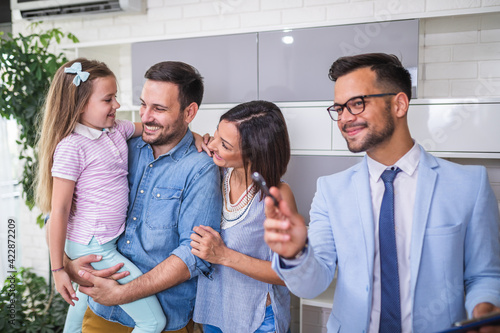 Happy family talking with real estate agent about buying a new home.