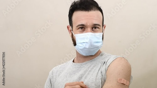 caucasian man vaccinate show his band-aid on his arm 