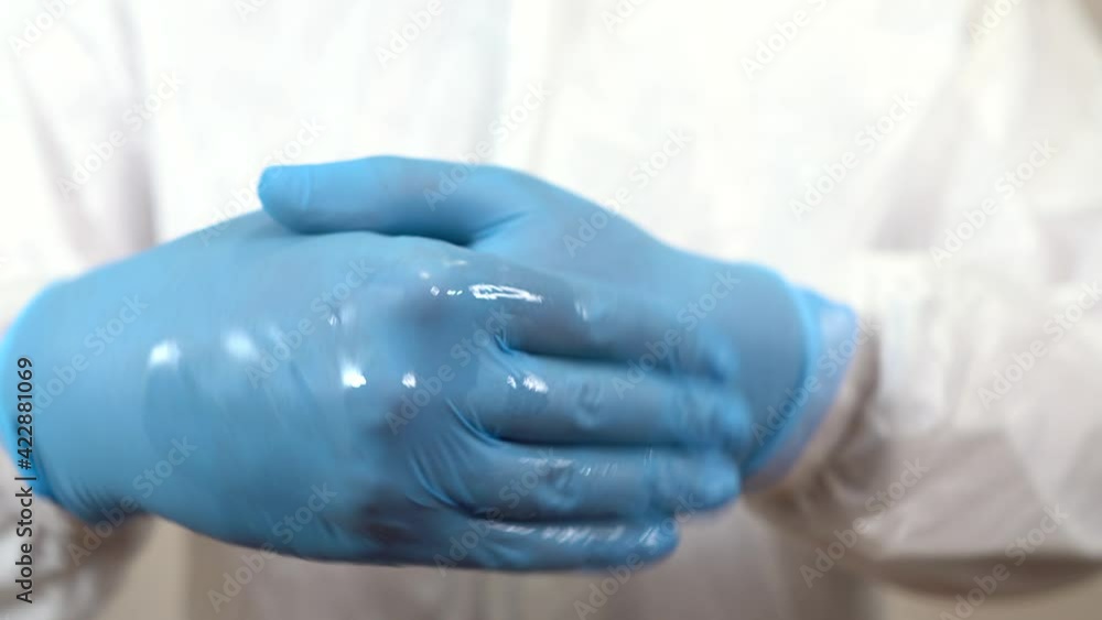 doctor in ppe cleans his hands with gel in front of the camera in a detail of his hands doctor in ppe cleans his hands with gel in front of the camera in a detail of his hands
