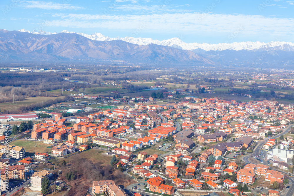 Flying over Venaria from Metropolitan City of Turin . Aerial view of Turin suburbs and Alps mountains
