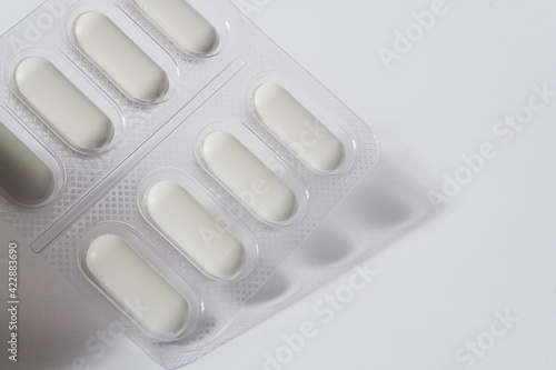 detail white pills with packaging on white background