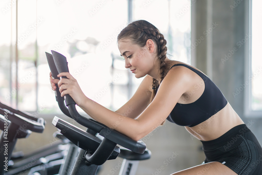 Beautiful sport woman working out on exercise bike at sport health club Beautiful sport woman working out on exercise bike at sport health club