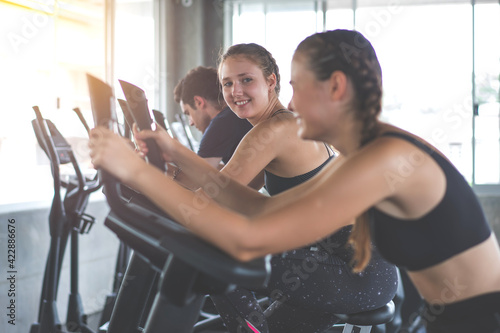 Beautiful sport woman working out on exercise bike at sport health club