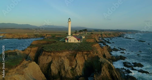 Lighthouse on the pacific coast from above, Point Arena, California coast line, aerial view of ocean waves, cliffs and rocks at Point Arena Mendocino County, United States, sunset windy day