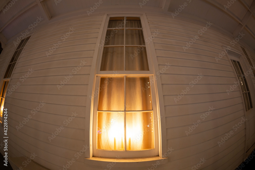 Obraz premium A fisheye view of the exterior of a home with candles lit in a window