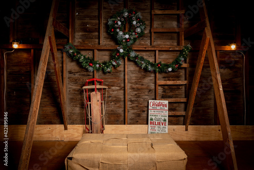 Rustic Christmas Scene in a Wooden Barn with Wreath and Sled