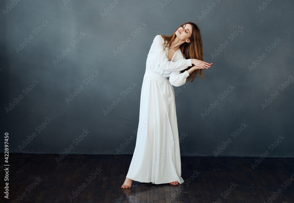 Woman in white dress on gray background red hair model romance Woman in white dress on gray background red hair model romance