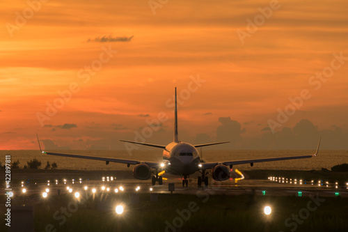 An airplane landing at an airport during sunset sky