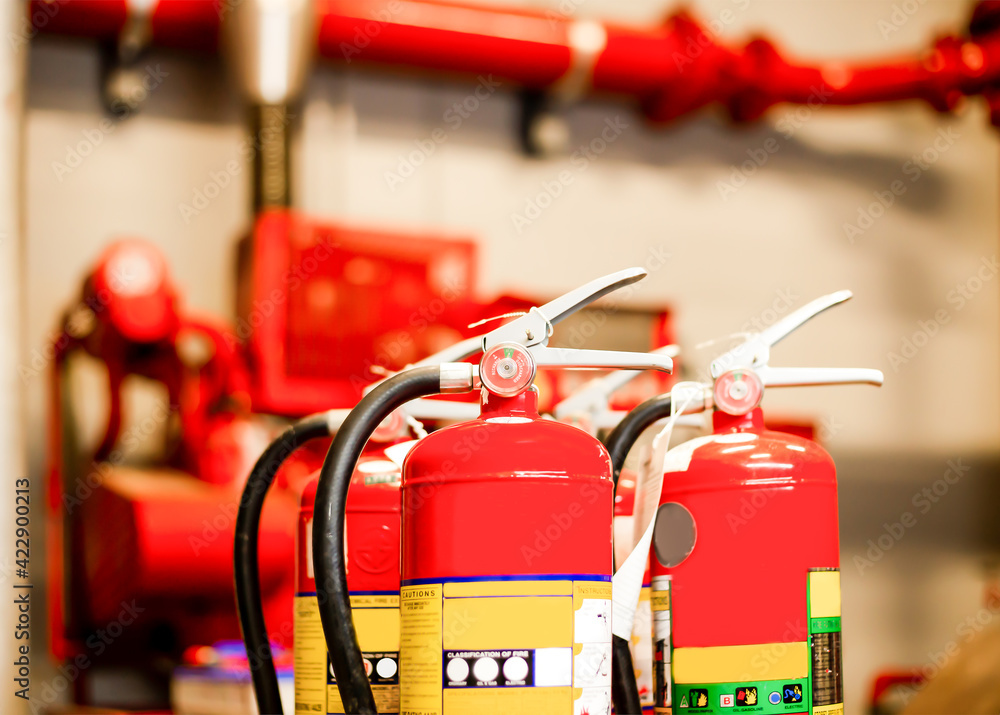 The red fire extinguisher is ready for use in case of an indoor fire emergency. The red fire extinguisher is ready for use in case of an indoor fire emergency.