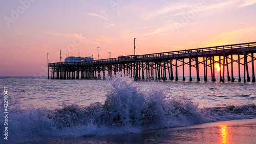 Scenic sunset over the Pacific ocean. A setting sun behind the long pier, Irvine, Orange County, California