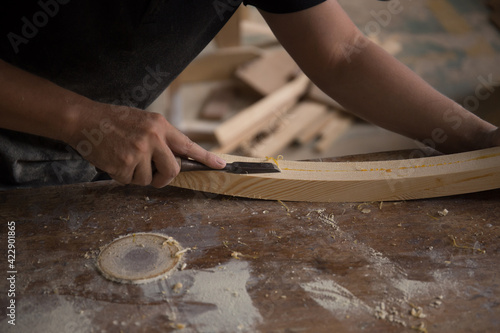 a carpenter using a chisel on a block of wood 