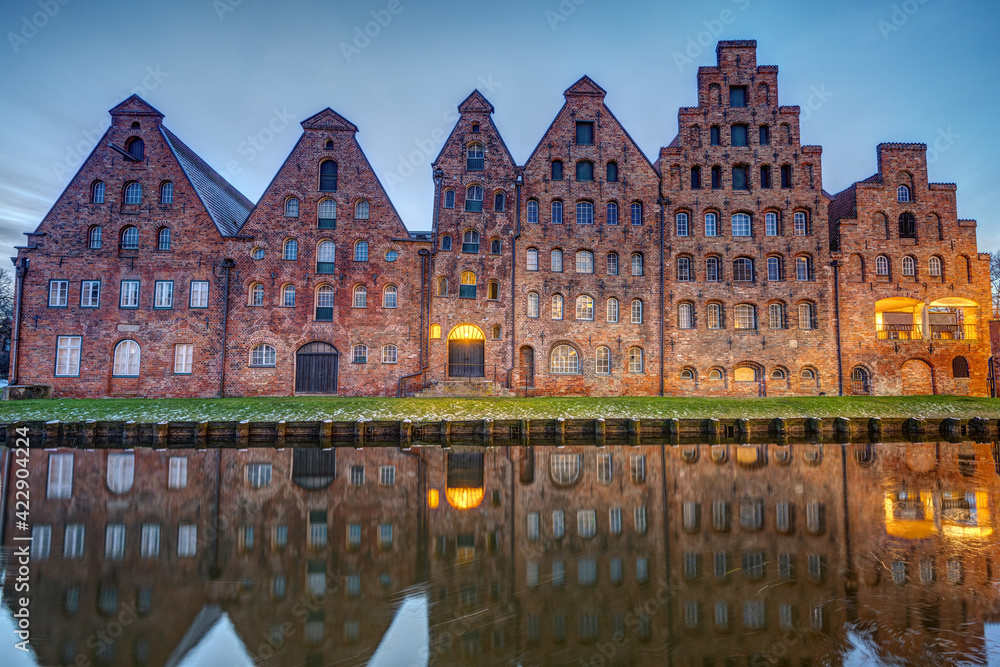 The old Salzspeicher reflecting in the Trave river at dawn, seen in Luebeck, Germany The old Salzspeicher reflecting in the Trave river at dawn, seen in Luebeck, Germany