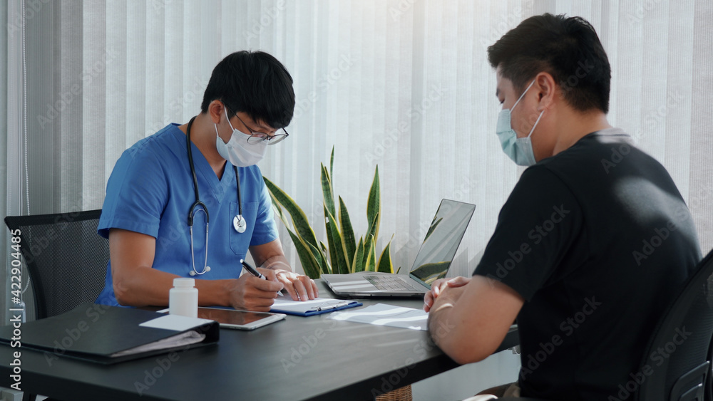 Doctors are explaining the treatment of a patient's illness while wearing a mask during the epidemic. Doctors are explaining the treatment of a patient's illness while wearing a mask during the epidemic.