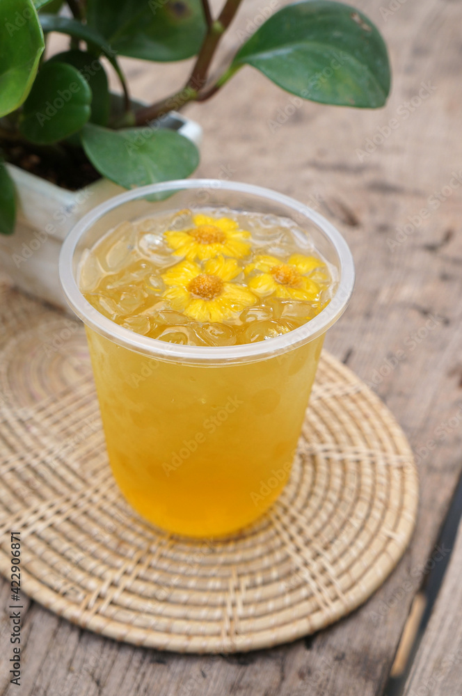 Chrysanthemum juice in a glass placed on a wooden table. Chrysanthemum juice in a glass placed on a wooden table.