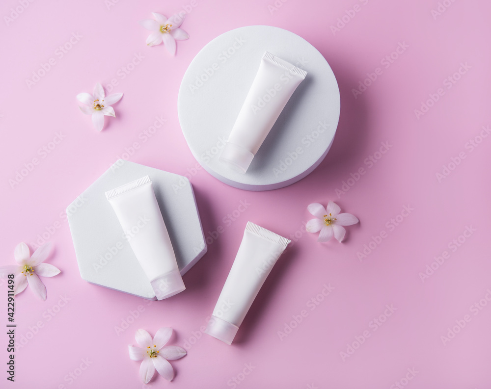 White tubes of cream on a pink background White tubes of cream on a pink background
