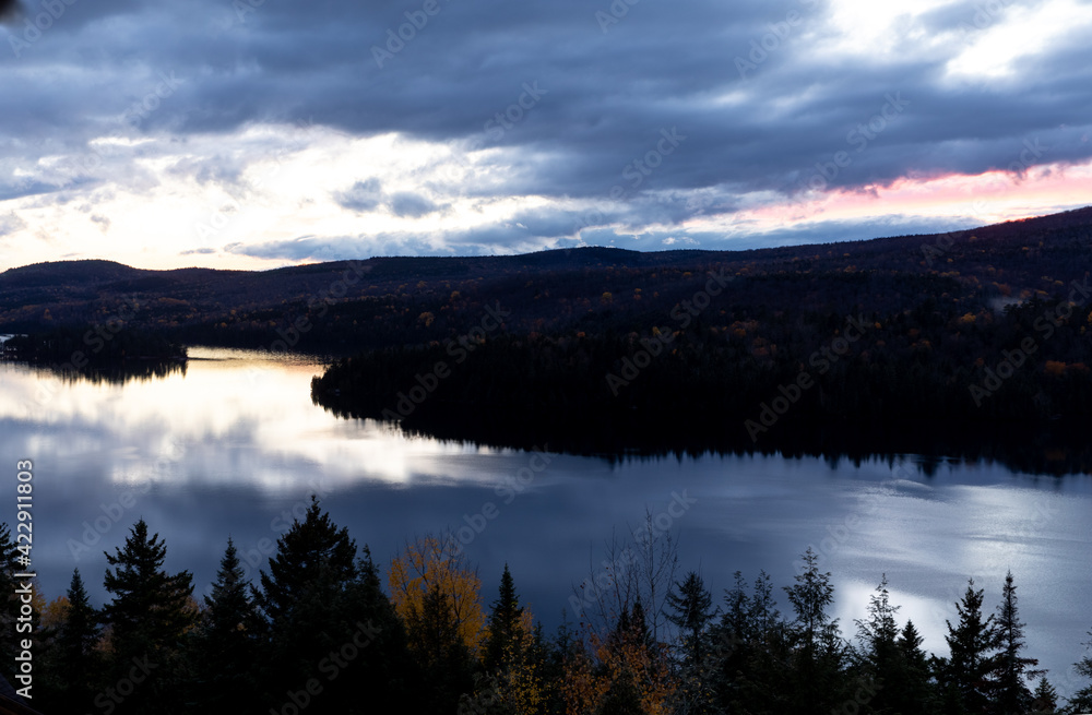 Vue d'un lac miroitant les nuages lors d'un coucher de soleil bleu dans la vallée