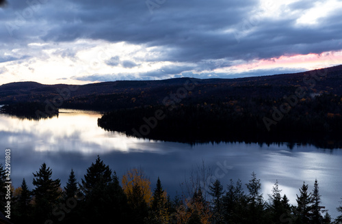 Vue d un lac miroitant les nuages lors d un coucher de soleil bleu dans la vall  e